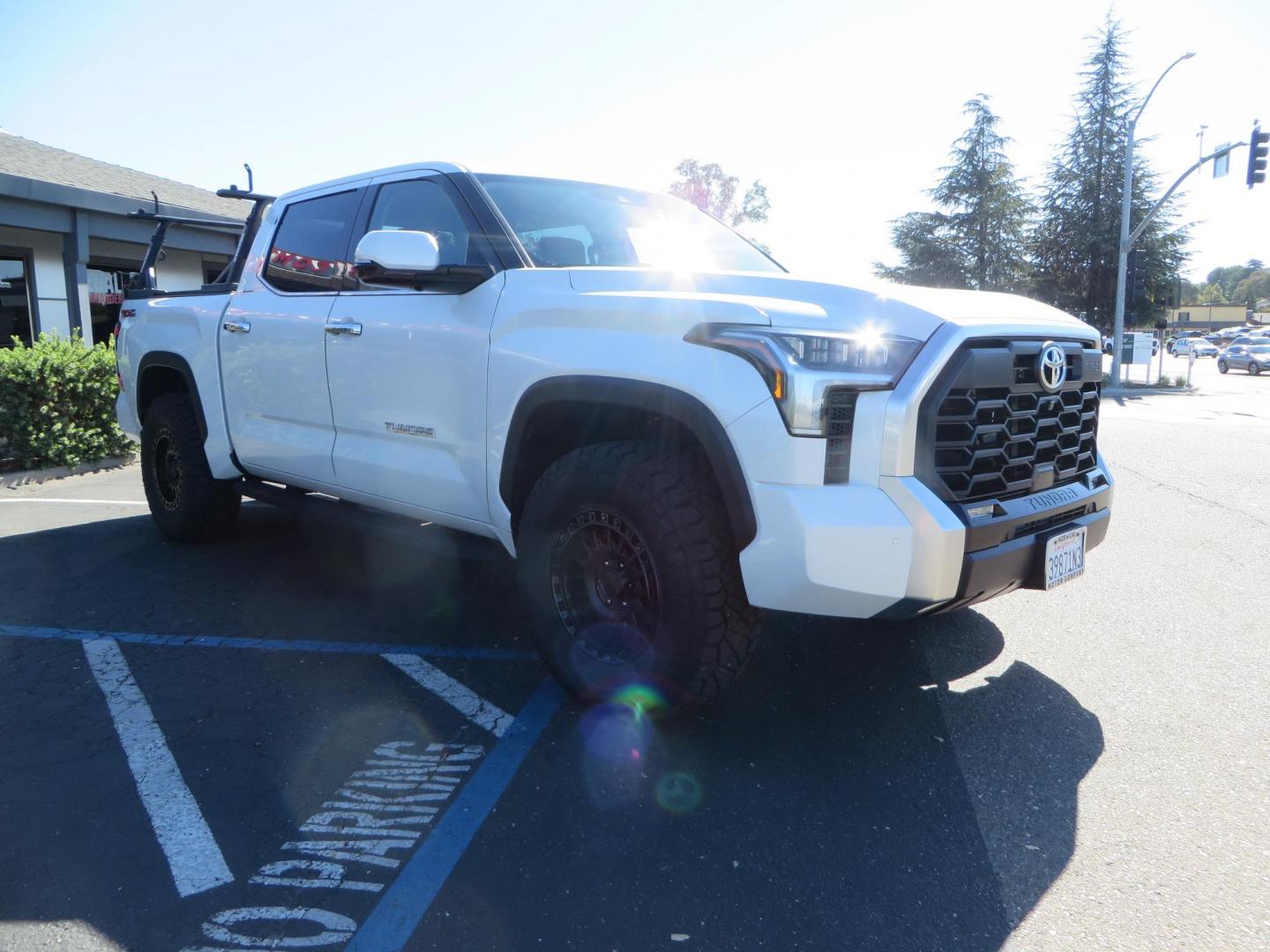 2022 White Toyota Tundra Limited CrewMax 2WD (5TFJA5AB0NX) with an 3.5L V6 DOHC 24V engine, 6A transmission, located at 2630 Grass Valley Highway, Auburn, CA, 95603, (530) 508-5100, 38.937893, -121.095482 - Tundra featuring a 2" leveling kit, 35" Nitto Ridge Grappler tires, 18" KMC IMS wheels, Retrax tonneau cover, and Yakima truck bed ladder rack. - Photo#2