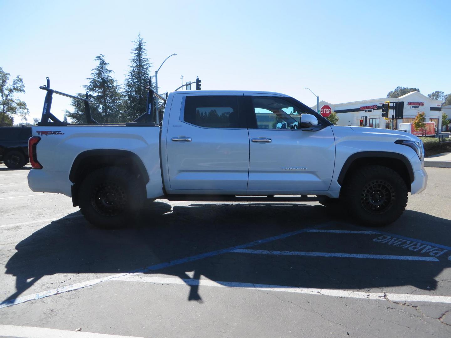 2022 White Toyota Tundra Limited CrewMax 2WD (5TFJA5AB0NX) with an 3.5L V6 DOHC 24V engine, 6A transmission, located at 2630 Grass Valley Highway, Auburn, CA, 95603, (530) 508-5100, 38.937893, -121.095482 - Tundra featuring a 2" leveling kit, 35" Nitto Ridge Grappler tires, 18" KMC IMS wheels, Retrax tonneau cover, and Yakima truck bed ladder rack. - Photo#3