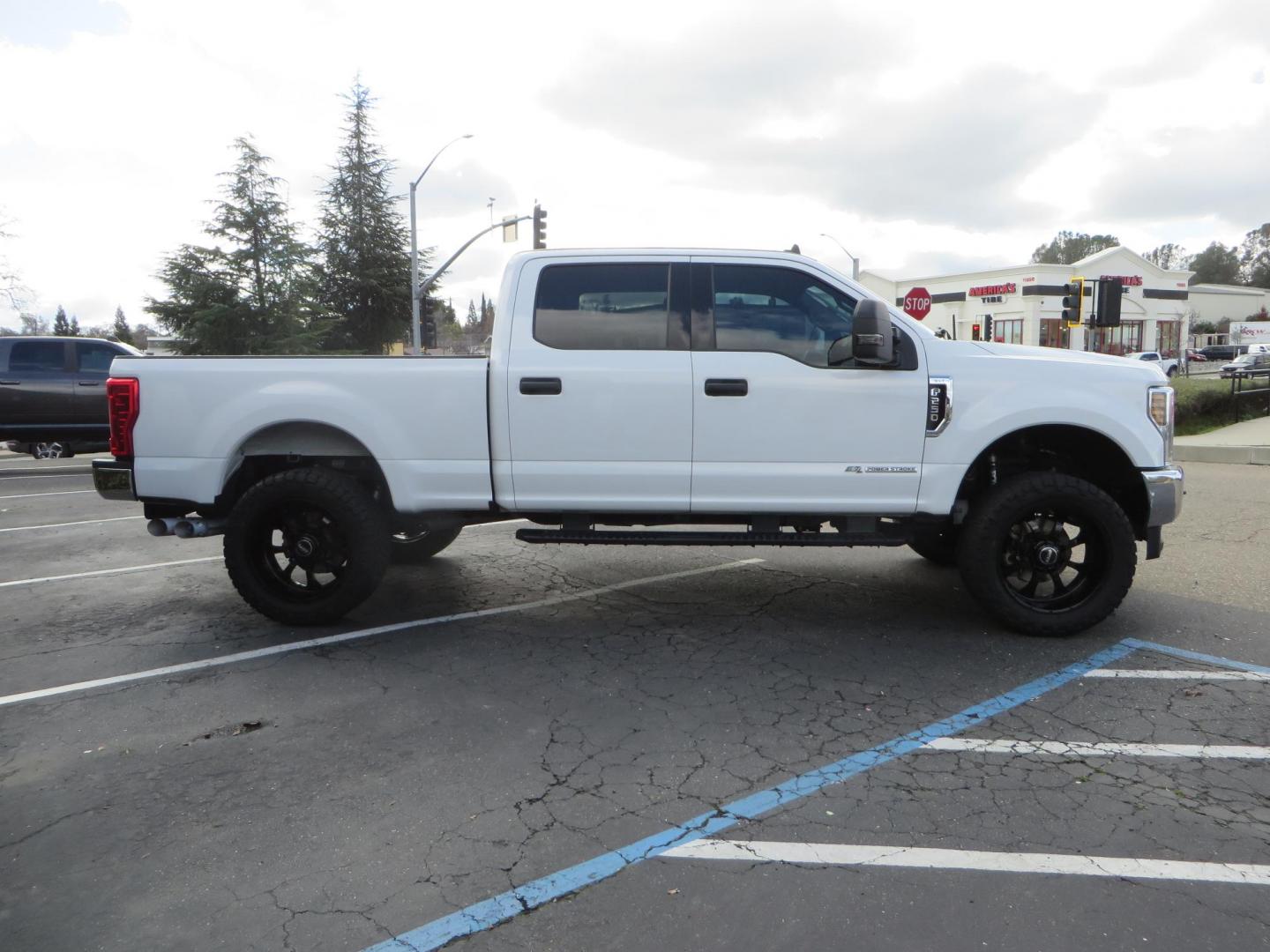 2019 White Ford F-250 SD XLT Crew Cab Short Bed 4WD (1FT7W2BT9KE) with an 6.7L V8 OHV 16V DIESEL engine, 6A transmission, located at 2630 Grass Valley Highway, Auburn, CA, 95603, (530) 508-5100, 38.937893, -121.095482 - Leveled XLT sitting on 22" SOTA Novakane wheels, 325 Nitto Ridge Grappler tires, Fox Shocks and dual steering stabilizers, Firestone Ride Rite air bags, Airlift wireless 1 air compressor, B&W Turnover gooseneck hitch, Weathertech floor liners, Deezee tailgate assist, and window tint. - Photo#3